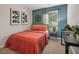 Bright bedroom with a blue accent wall, featuring modern artwork, a comfortable bed, and a work desk at 2272 Jamin Bnd # 13, Lithonia, GA 30058