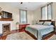 Comfortable bedroom with a fireplace, wooden floors, large bed, and patterned curtains at 561 Culberson Sw St, Atlanta, GA 30310