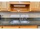 Stainless steel sink with granite countertops and wood cabinets at 1050 Sunny Field Ct, Lawrenceville, GA 30043