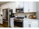 Kitchen details include stainless steel appliances, gas range, backsplash, and white countertops at 1560 Baygreen Rd, Suwanee, GA 30024