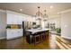 Bright kitchen features stainless appliances, white cabinets, large center island, and pendant lighting at 1560 Baygreen Rd, Suwanee, GA 30024