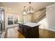 Bright kitchen with a large island that features bar seating, a sink, and pendant lighting at 1560 Baygreen Rd, Suwanee, GA 30024
