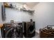 Well-equipped laundry room featuring front loading washer and dryer, plus convenient shelving at 1560 Baygreen Rd, Suwanee, GA 30024