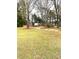 Large grassy backyard with mature trees and an outbuilding offering ample space for outdoor activities at 3503 Saddlebrook Dr, Loganville, GA 30052