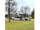 Charming home with screened porch and white bench, set on a lush green lawn with mature trees at 3503 Saddlebrook Dr, Loganville, GA 30052