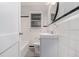 This bathroom has white tile walls with a black accent stripe and a dark gray floor at 864 Northview Dr, Forest Park, GA 30297