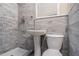 Updated bathroom showcasing tiled walls, pedestal sink, and modern toilet at 864 Northview Dr, Forest Park, GA 30297