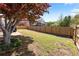 Large backyard with a wooden fence and mature trees offers a sense of privacy and seclusion at 5330 Maltdie Ct, Sugar Hill, GA 30518