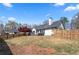 Large backyard is fully fenced and features a patio with seating, grilling area, and mature shade trees at 5330 Maltdie Ct, Sugar Hill, GA 30518