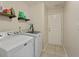 Bright laundry room features a side-by-side washer and dryer, shelving, and easy access to the exterior at 5330 Maltdie Ct, Sugar Hill, GA 30518