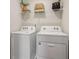 Well-lit laundry room with a modern washer and dryer set and a shelf for storage at 5897 Mattan Trl # 67, Lithonia, GA 30058