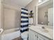 Bathroom with a tub and a shower with blue and white striped shower curtain and large mirror at 7725 Bold Springs Xing, Cumming, GA 30041