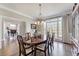 Open concept dining room with hardwood floors, large window, and view to living room at 7725 Bold Springs Xing, Cumming, GA 30041