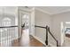 Well-lit hallway with wood floors, a view of a sunlit office, and black and white banister at 7725 Bold Springs Xing, Cumming, GA 30041
