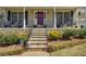 Charming front entrance with stone steps, wrought iron railing, manicured landscaping, and a colorful wreath at 802 Sugar Creek Se Dr, Conyers, GA 30094