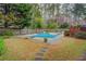 Backyard in-ground pool is surrounded by lush landscaping and a privacy fence at 802 Sugar Creek Se Dr, Conyers, GA 30094