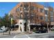 Elegant brick building with multiple stories, arched entrance, and awning-covered storefronts on a sunny day at 1430 Dresden Dr # 225, Atlanta, GA 30319