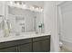 Bathroom featuring double vanity, dark cabinets, and shower/tub combo with neutral tile at 2120 Sonoma Se Dr, Smyrna, GA 30080
