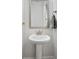 Bathroom features a pedestal sink, decorative mirror, and neutral color scheme at 2120 Sonoma Se Dr, Smyrna, GA 30080