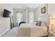 Bright bedroom featuring tufted headboard, mounted TV, accent chair and bedside table at 2120 Sonoma Se Dr, Smyrna, GA 30080