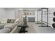 Bright living room features a large couch, exercise equipment, and shelving with a beverage cooler at 2120 Sonoma Se Dr, Smyrna, GA 30080