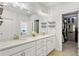 Well-lit bathroom featuring double vanity with granite countertops and access to a custom walk-in closet at 2120 Sonoma Se Dr, Smyrna, GA 30080