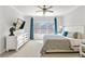 Bright main bedroom featuring large window, modern ceiling fan, tv, and comfortable king bed at 2120 Sonoma Se Dr, Smyrna, GA 30080