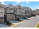 Charming street view of a new townhome community with brick and siding exteriors, two-car garages and manicured lawns at 2120 Sonoma Se Dr, Smyrna, GA 30080