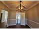 Elegant dining room features a modern light fixture and beautiful wainscoting, perfect for Gathering gatherings at 79 Dogwood Ferry Ct, Lawrenceville, GA 30046
