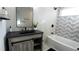 Stylish bathroom with modern vanity, large mirror, and bathtub with tiled walls at 1031 Camilla Sw St, Atlanta, GA 30314