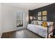A bedroom with dark accent wall, laminate floors, bright yellow accents and natural light from the window at 210 Woodcliff Dr, Atlanta, GA 30350