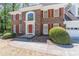 Close-up of a brick home with red shutters, manicured bushes, and a paved walkway at 3590 Lester Sw Ct, Lilburn, GA 30047