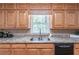 A kitchen featuring wood cabinets, granite countertops, and a stainless steel sink at 3590 Lester Sw Ct, Lilburn, GA 30047