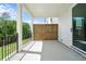 Covered back porch with sleek concrete flooring, framed by white pillars and a black metal railing at 636 Silva St, Cumming, GA 30040
