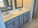 Bathroom featuring dual sinks, gray cabinets and marble-look floors at 636 Silva St, Cumming, GA 30040