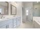 Bathroom with double vanity, marble-like tile flooring, and a glass-enclosed shower at 636 Silva St, Cumming, GA 30040