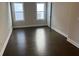 A large bedroom with hardwood floors, two windows and a door at 636 Silva St, Cumming, GA 30040