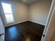 Cozy bedroom features hardwood floors, natural light from a large window, and neutral paint at 636 Silva St, Cumming, GA 30040