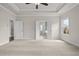 Spacious carpeted bedroom with tray ceilings, windows, and multiple doorways at 636 Silva St, Cumming, GA 30040