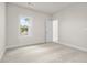 A bright bedroom featuring neutral walls, plush carpeting, and a window offering an outside view at 636 Silva St, Cumming, GA 30040