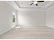 Spacious bedroom with a tray ceiling, ceiling fan, neutral carpet, and a large window offering natural light at 636 Silva St, Cumming, GA 30040
