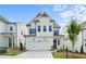 Charming two-story home with white siding, black shutters, well-manicured lawn, and attached two-car garage at 636 Silva St, Cumming, GA 30040