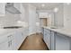Modern kitchen featuring white cabinets, stainless steel appliances, a gas cooktop, and an island with a sink at 636 Silva St, Cumming, GA 30040