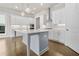 Modern kitchen featuring white cabinets, a stainless steel range hood, a kitchen island, and hardwood floors at 636 Silva St, Cumming, GA 30040