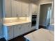 Bright kitchen featuring white cabinets, modern appliances, sleek countertops, and task lighting at 636 Silva St, Cumming, GA 30040