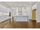 Well-lit kitchen featuring white cabinets, stainless steel appliances, a kitchen island, and hardwood floors at 636 Silva St, Cumming, GA 30040