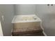 A soaking tub sits on a platform and is surrounded by tiled accents at 2039 Corners Cir, Lithonia, GA 30058