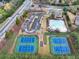 Aerial view showcasing tennis courts, a community pool, parking, and surrounding greenery at 4720 Gablestone Xing, Hoschton, GA 30548