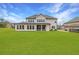 Large backyard with a covered patio, well-maintained lawn, and privacy fence at 4720 Gablestone Xing, Hoschton, GA 30548