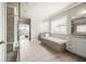 This bathroom features a luxurious tub, double vanity and glass-enclosed shower at 4720 Gablestone Xing, Hoschton, GA 30548